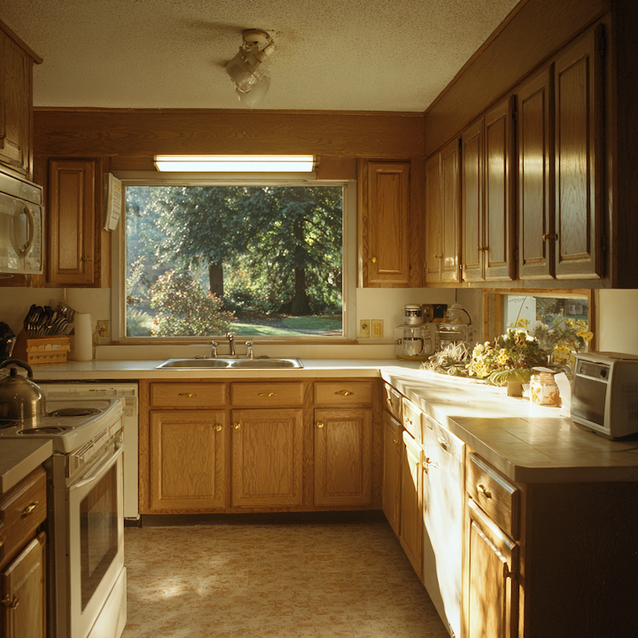 1990s oak kitchen with laminate counters and brass hardware before a Memphis remodel